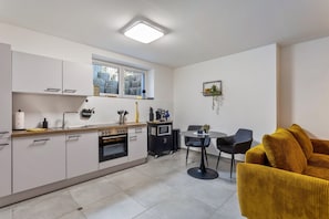 A compact kitchen with a dining area, a microwave, and a small table with chairs.