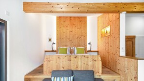 Une pièce moderne avec un mur d’accent en bois, un canapé et une petite table avec des lampes.