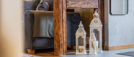 A wooden floor, a sofa, and two white lanterns.