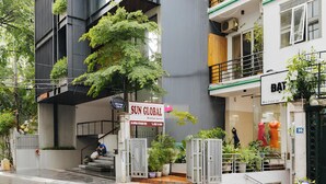 A multi-story building with a 'SUN GLOBAL' sign, a staircase, and a storefront with mannequins. - Ha Noi Memory Apartel (Hanoi)