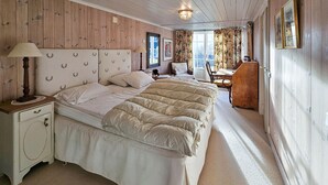 A bedroom with a large bed, a nightstand, a dresser, and a desk with a chair. - 4 bedroom beautiful home in Hemsedal (Hemsedal)