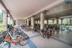 A covered bike parking area with multiple bicycles and baskets.