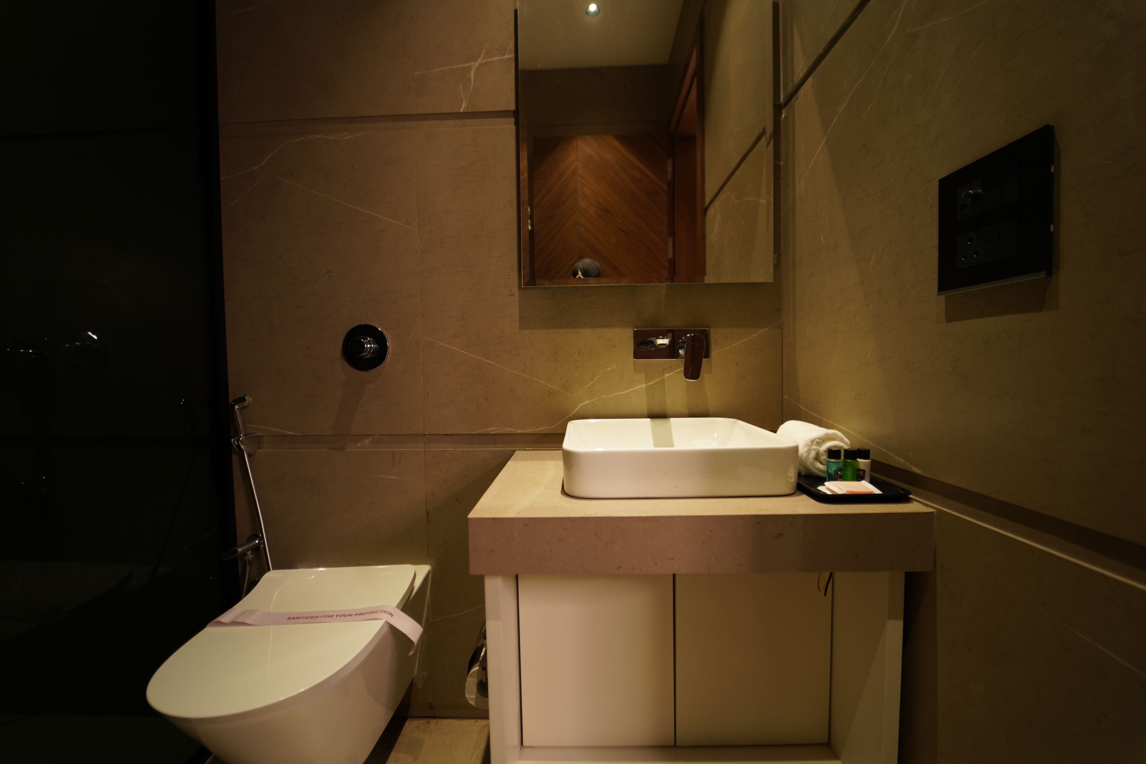 Un bagno con il water, un lavandino e uno specchio.