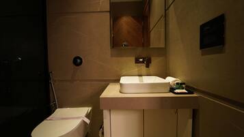 Un bagno con il water, un lavandino e uno specchio.
