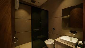 A modern bathroom with a glass-enclosed shower, a white sink, and a mirror above it.