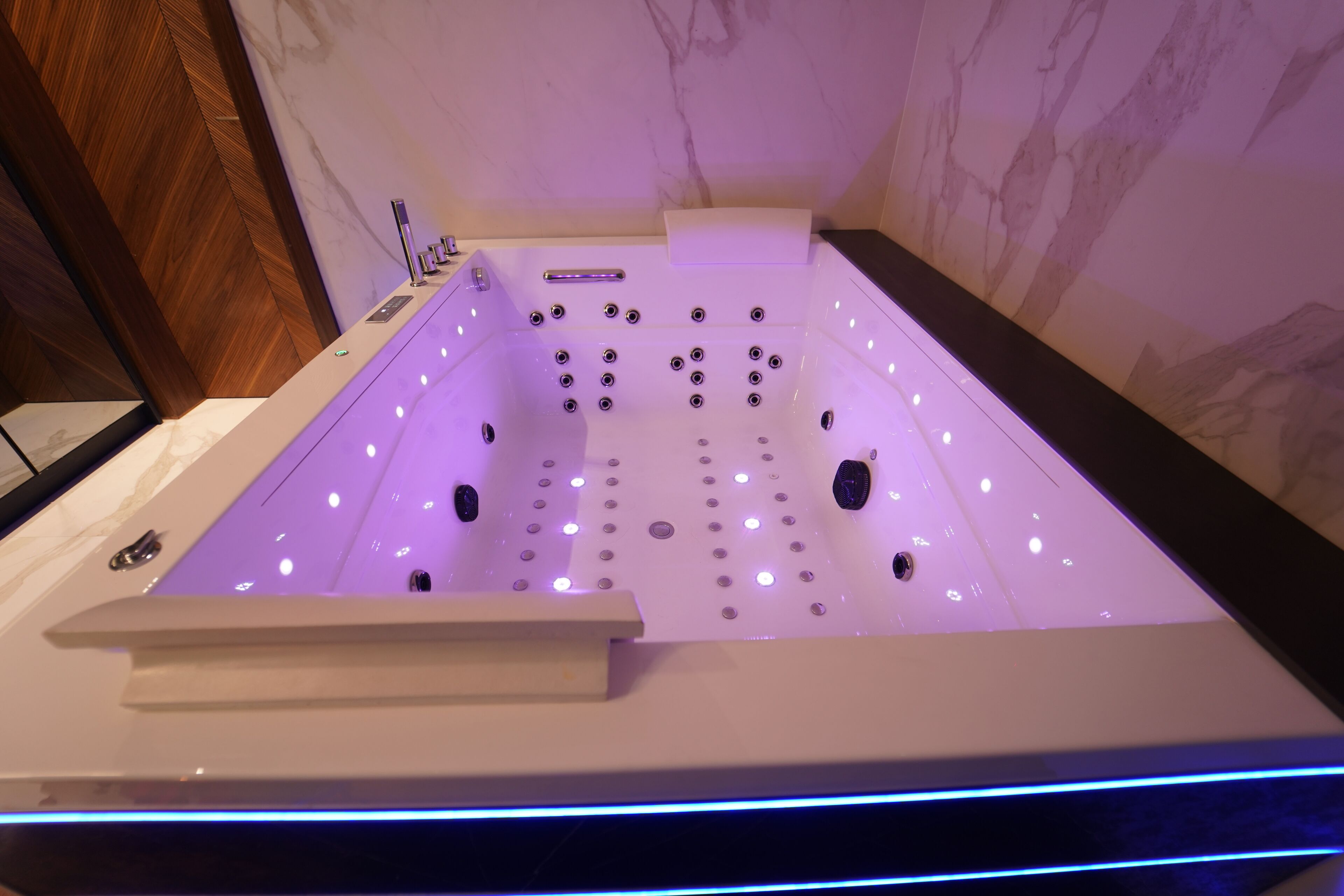 Eine moderne Whirlwanne mit mehreren Düsen, einer Steuerung und LED-Beleuchtung.