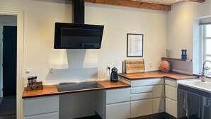 A modern kitchen with a built-in oven, a microwave, and a coffee maker on the counter.