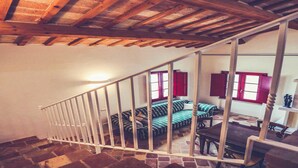 Eine Treppe mit Holzboden und weißen Geländern, die in einen Wohnbereich mit Sofa und Tisch führt.
