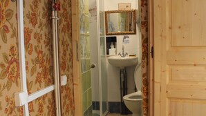 Et badeværelse med brusebad, toilet og vask.