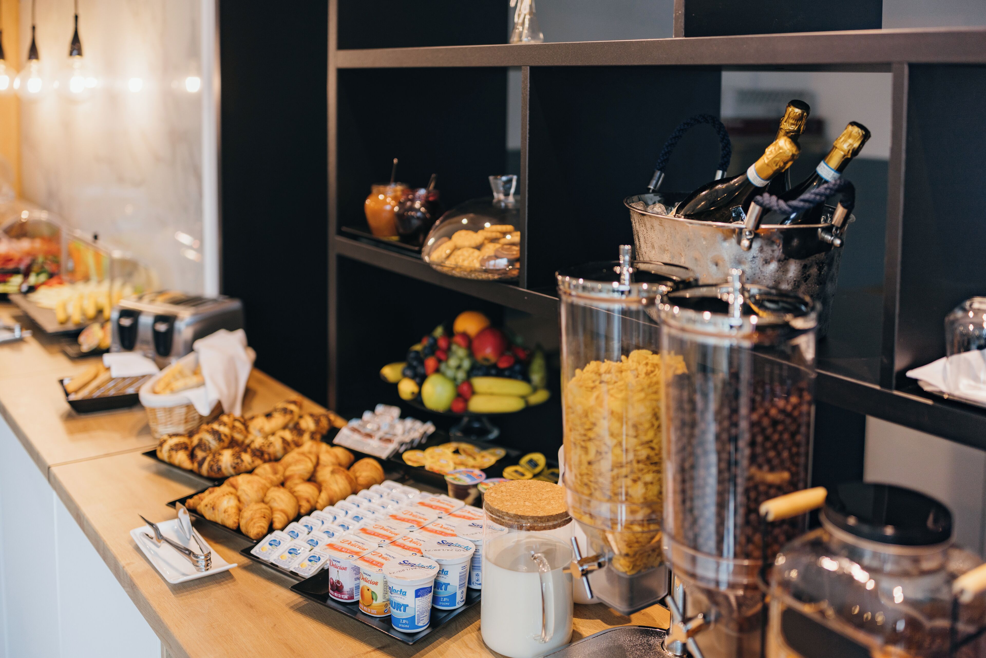 Un bufé con diferentes opciones de comida, como pasteles, frutas y bebidas.