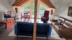A loft-style room with a dining area, a massage chair, a sofa, and a TV. - Apartment Kelkheim (Kelkheim (Taunus))