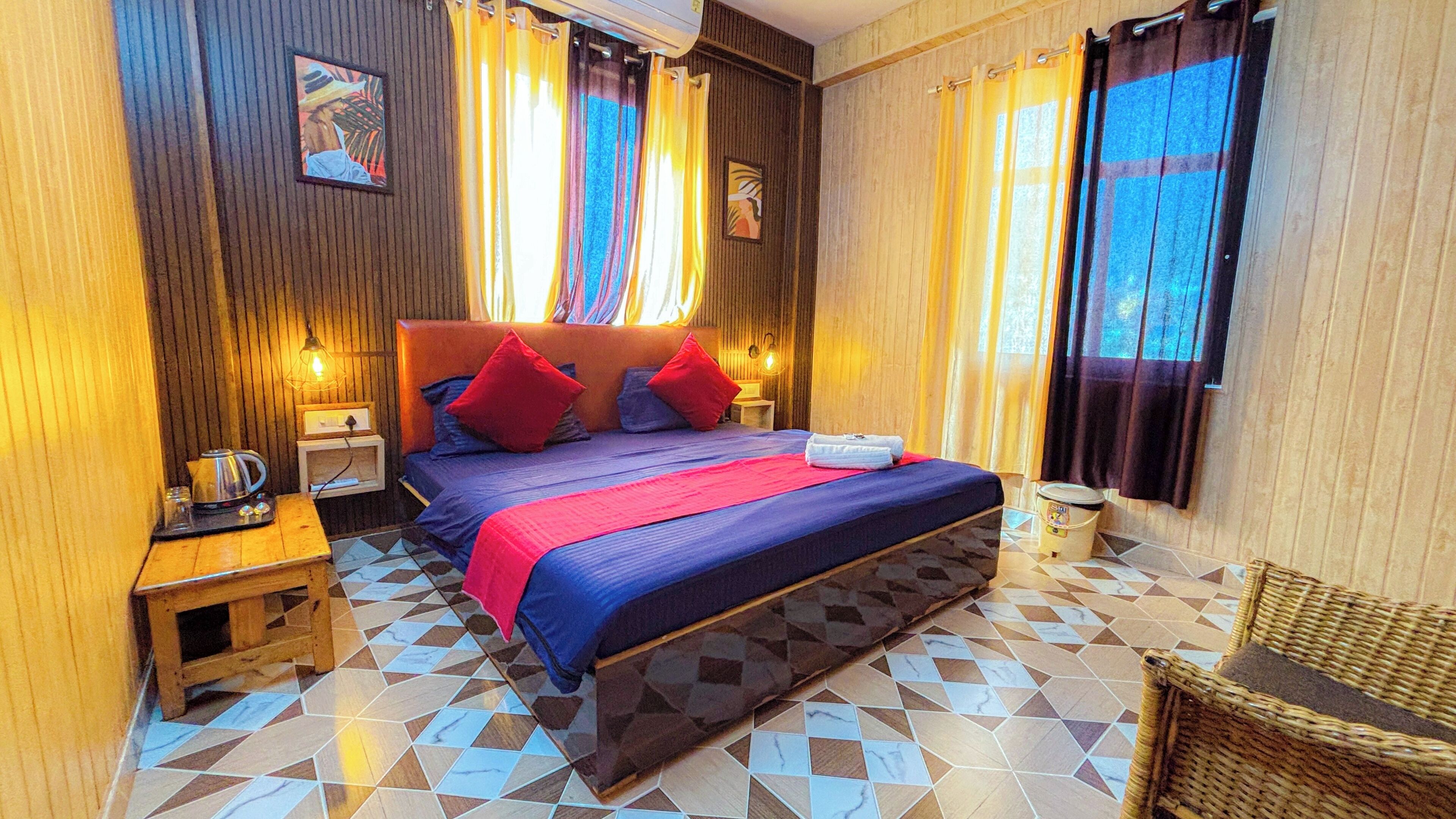Habitación de hotel con una cama grande, paredes de madera y baldosas de suelo estampadas.