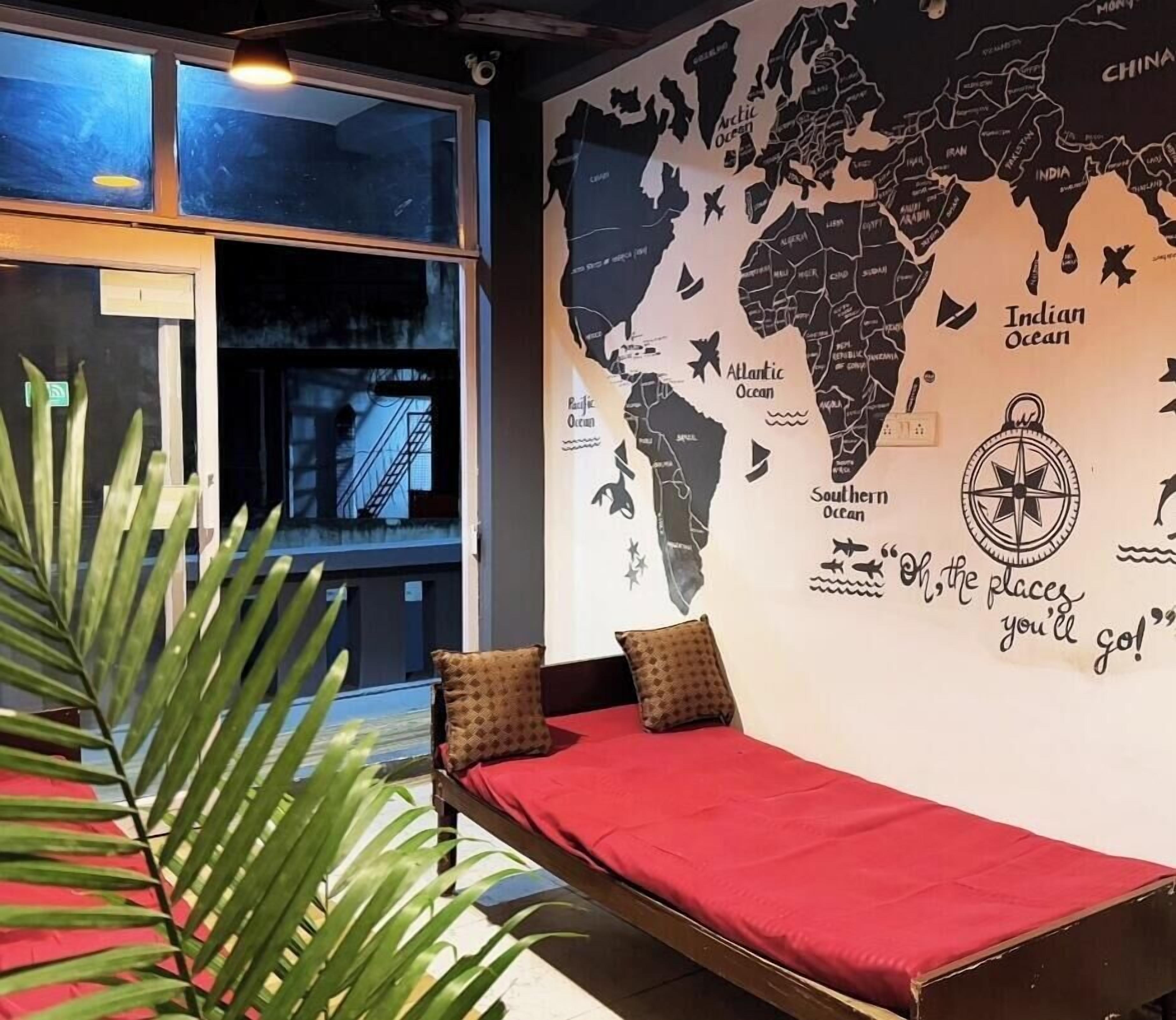 A room with a bed, a world map mural, and a large window.