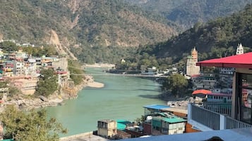 A river flowing through a mountainous area with buildings on the riverbank.