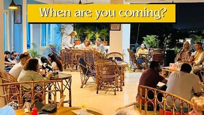 Un espace repas à l’auberge Skyard, avec des meubles en osier et une table centrale où sont disposés des plats et des boissons.