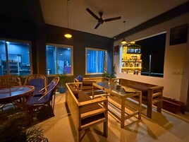 A modern dining area with wooden furniture and large windows.