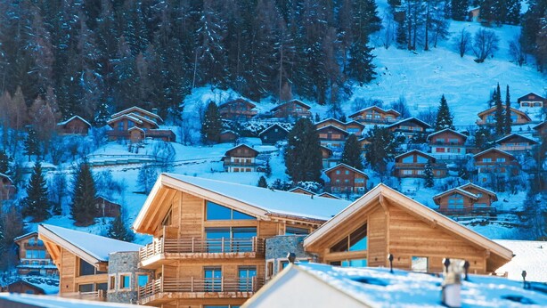 A cluster of wooden cabins with balconies, set against a snowy mountain backdrop. - Beautiful apartment for 6 guests with WIFI, TV and terrace (Basse-nendaz)