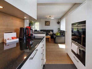 Een moderne keuken met een zwart aanrecht, een koffieapparaat en een Siemens oven.