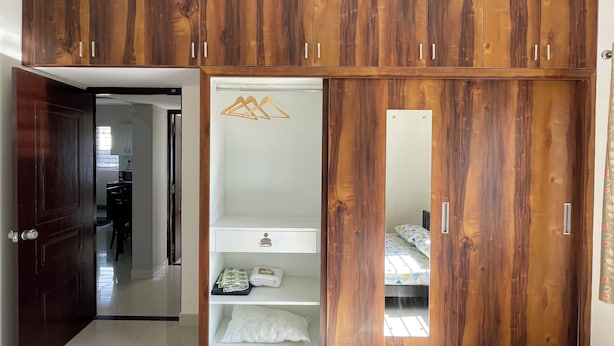 A wardrobe with multiple compartments and a mirror.