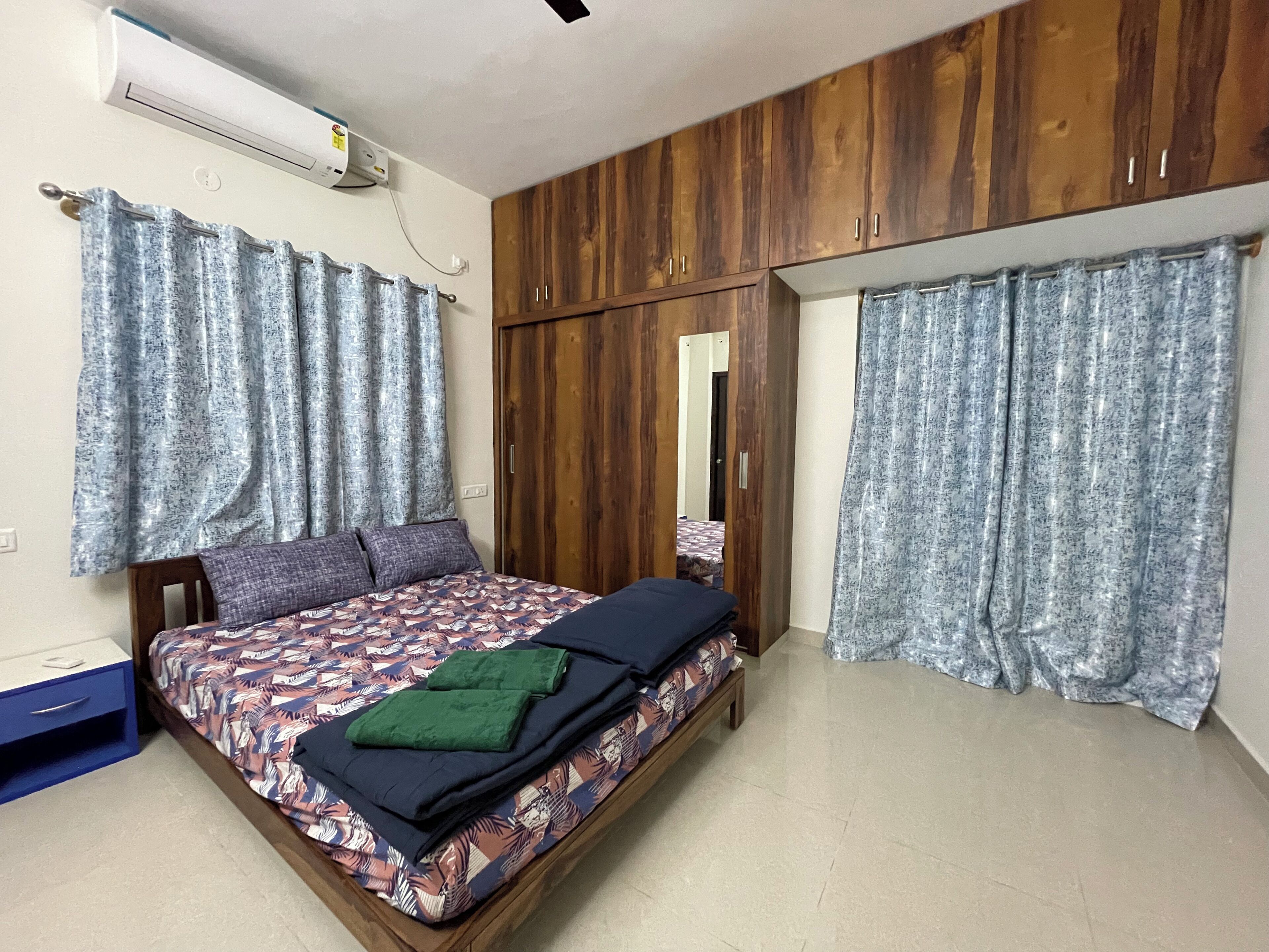 Un dormitorio con cama, armario de madera y espejo.
