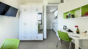 Ein moderner, kompakter Wohnraum mit Küchenzeile, Essbereich und Arbeitsplatz.