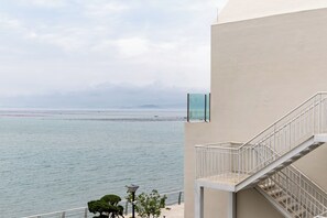 Un bâtiment situé sur la côte, doté d’un balcon donnant sur la mer, d’un escalier et offrant une vue dégagée sur le littoral.