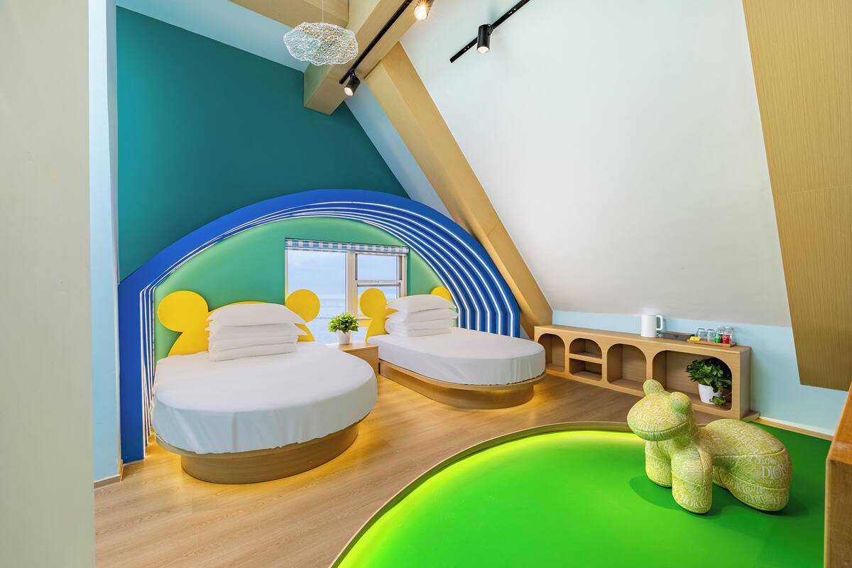 Ein Schlafzimmer mit zwei Betten, einer grünen Badewanne und einem Bären-Sessel.