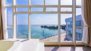 A room with large windows overlooking a marina and a pier. - Tangchi Seaview Resort (Weihai)