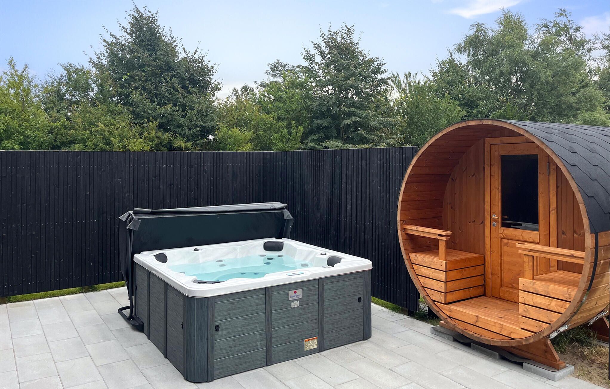 A hot tub and a wooden sauna in an outdoor setting.