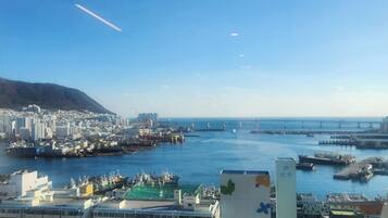 A coastal cityscape with a marina, buildings, and a clear blue sky.