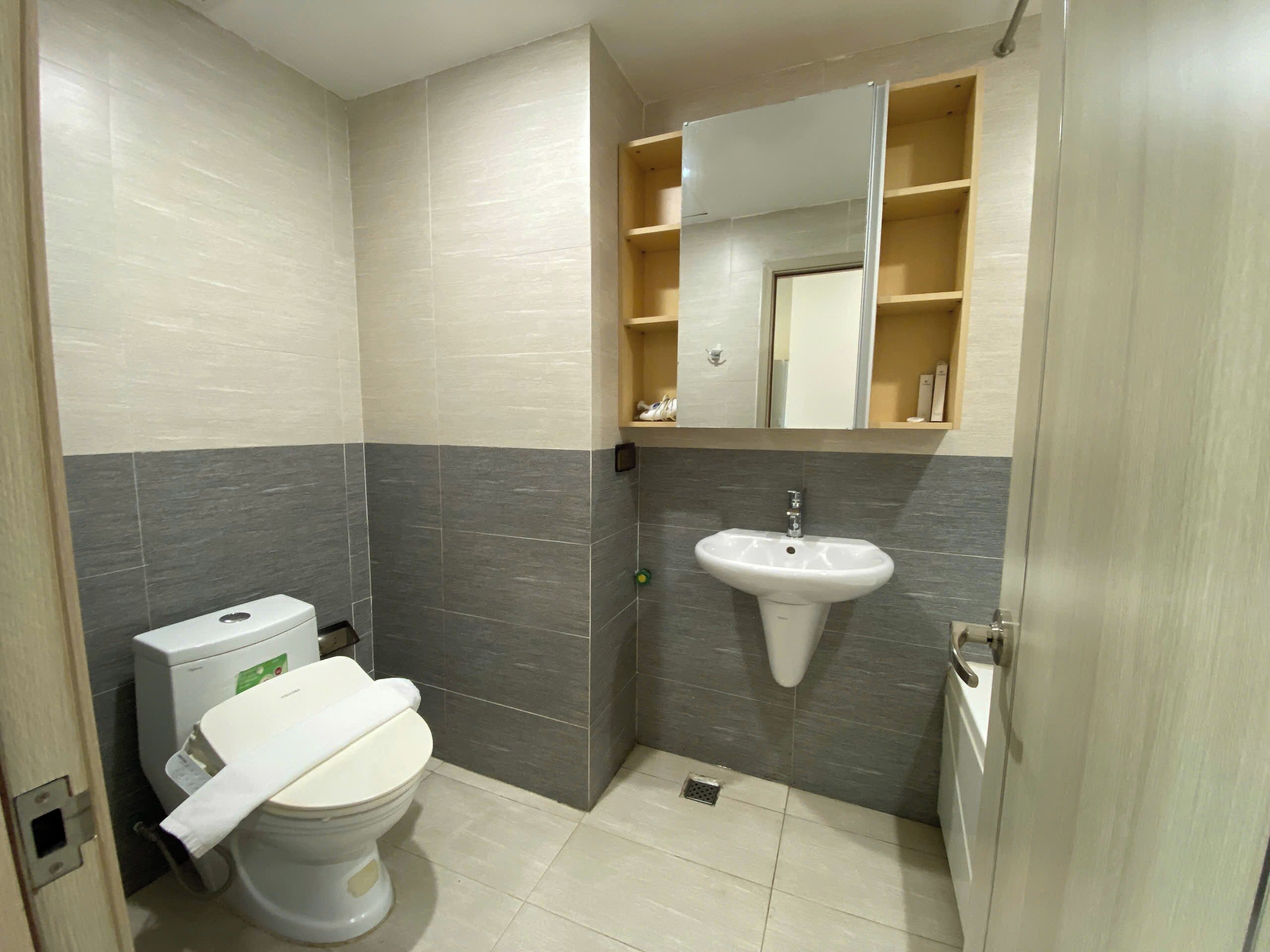 A compact bathroom with a toilet, a sink, and a mirror above the sink.