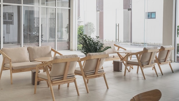 Un'area salotto moderna e interna, con arredi in legno e un'ampia pianta in vaso.