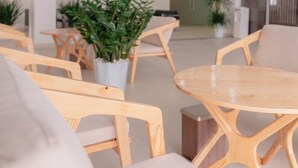 Un interno moderno con arredi in legno, un tavolo rotondo e piante in vaso.