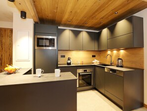 Una cocina moderna con microondas, horno y lavavajillas integrados.