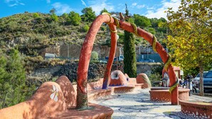 A tiled pathway with sculptural elements and a hilly landscape in the background. - Casa Nobleza in C Mpeta (Còmpeta)
