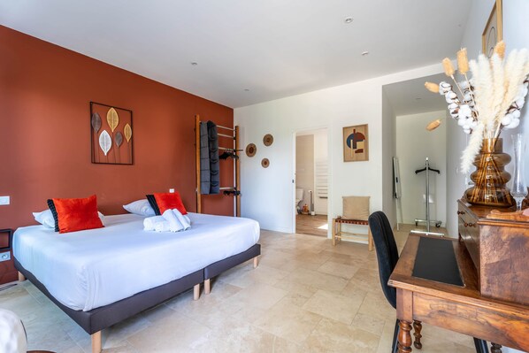 A bedroom with a bed, a desk, and a chair.