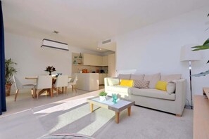 Una sala de estar moderna con un sofá, una mesa de centro y una zona de comedor.