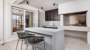 A modern kitchen with a central island, bar stools, a built-in stove, and a large window overlooking the living area. - Cozy home in Skrip with WiFi (Skrip)
