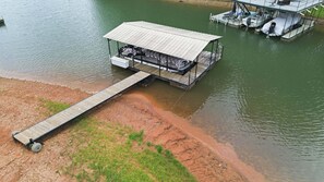 A dock extending into a body of water with a covered structure on it, possibly a boat house or storage area.