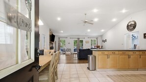 A spacious kitchen with a dining area, a large island, and a view of the outdoors.