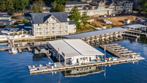 An aerial view of a waterfront property with a large building, docks, and boats.