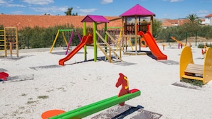 Un parque infantil con diversas estructuras de juego, incluyendo toboganes y columpios.