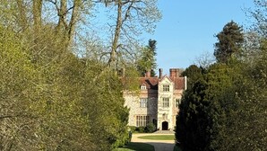 A pathway leading to a large stone building with a symmetrical facade, surrounded by well-maintained grass and trees. - The Garden Rooms, Selborne - Jane Austin country & the South Downs National Park (Selborne)