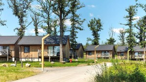 A row of wooden cabins with balconies, surrounded by trees and a clear sky. - Stunning home in Somme-Leuze with WiFi (Somme-Leuze)