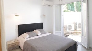 A bedroom with a bed, bedside tables, a red rug, and a sliding glass door leading to an outdoor area. - Villa Anza de la Olla - Le Racou plage - 13 people - 5 bedrooms (Argelès-sur-Mer)
