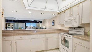 A modern kitchen with white cabinets, a microwave, and an oven.
