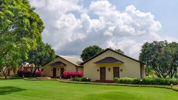 Two single-story buildings with a flat roof, surrounded by well-maintained lawns and trees.