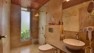 Un baño moderno con un ventanal grande, ducha, inodoro, lavamanos con espejo y secador de pelo.