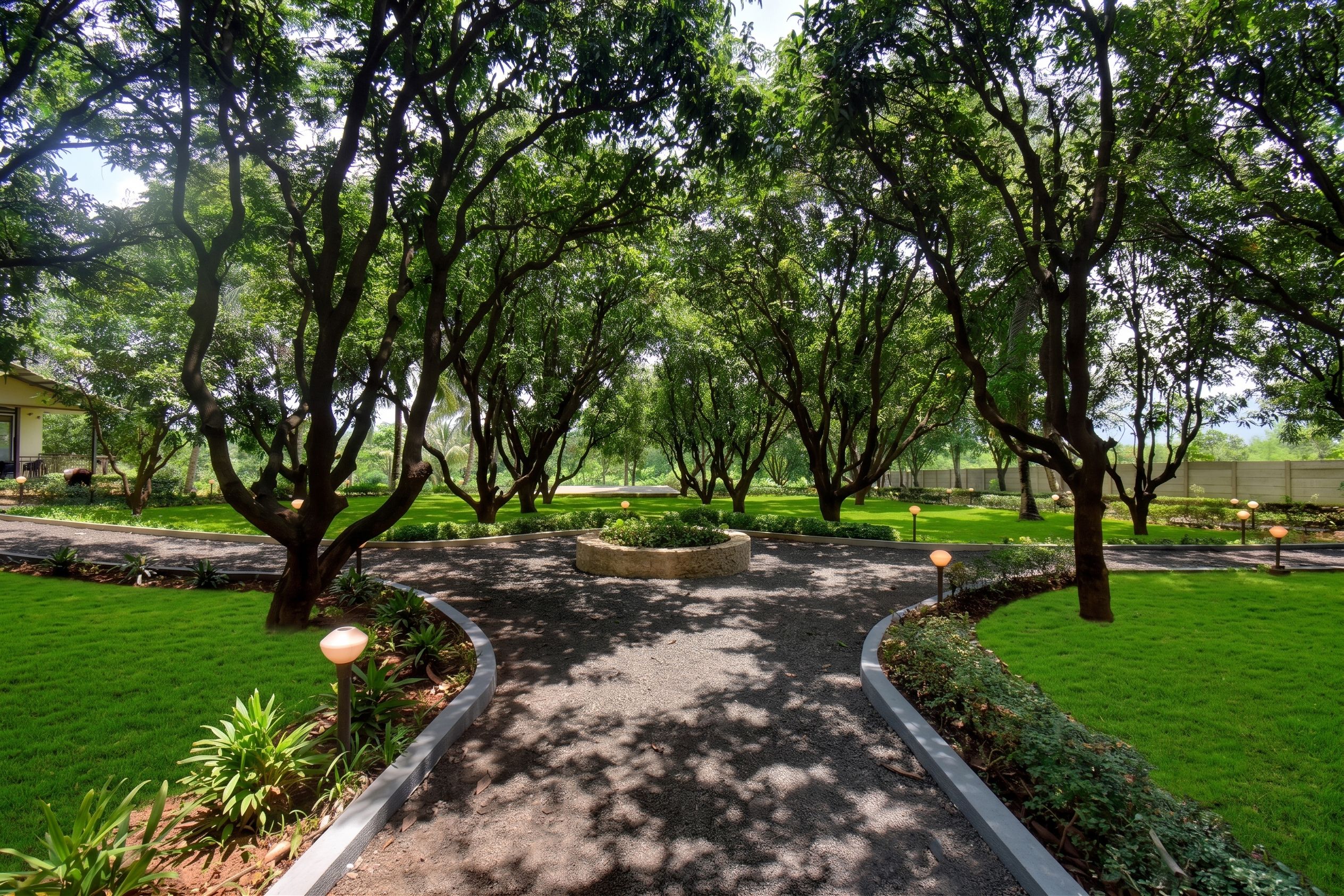 Un sentier qui traverse un espace verdoyant, aménagé comme un parc, avec des arbres et une pelouse bien entretenue.