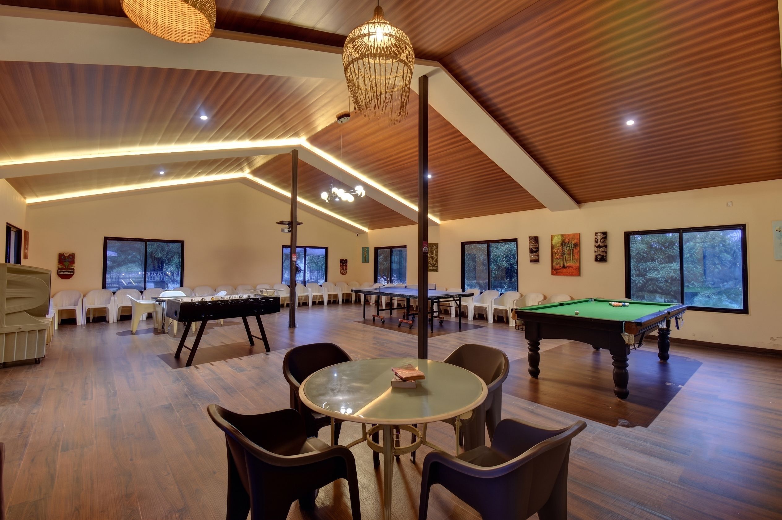 A spacious indoor area with a pool table, billiards table, and a billiard cue rack.